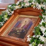 Храмовый флорист украшает иконы к православным праздникам в кочковском храме